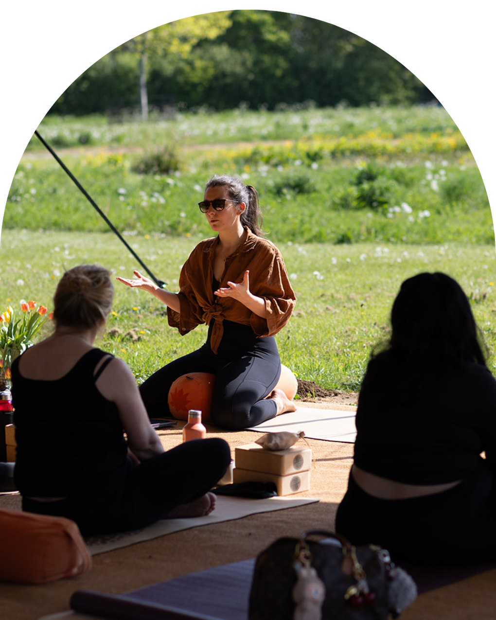 Bronwyn Benstead running a women's retreat in Derbyshire Bronwyn Benstead in a sunny field running a yoga session